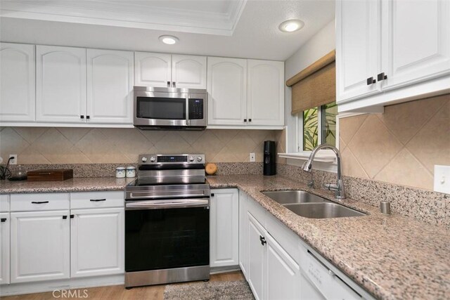 856 Ronda Mendoza Unit P, Laguna Woods, CA 92637 - kitchen with stainless steel appliances, crown molding, white cabinets, backsplash, and light stone countertops