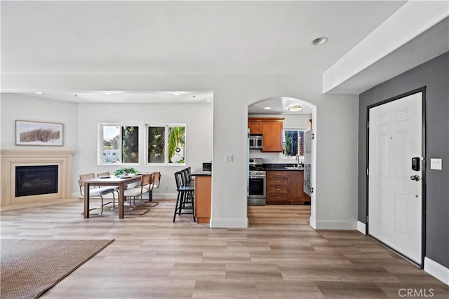 9123 National Blvd Unit 1, Los Angeles, CA 90034 - kitchen featuring stainless steel appliances, dark countertops, brown cabinets, a glass covered fireplace, and open floor plan