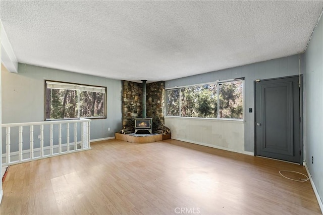 25286 N Rd, Twin Peaks, CA 92391 - unfurnished living room with wood finished floors, a wood stove, and a textured ceiling