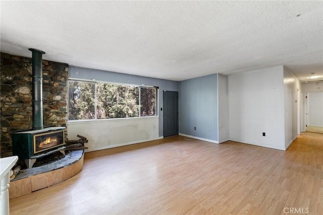 25286 N Rd, Twin Peaks, CA 92391 - unfurnished living room featuring a textured ceiling, a wood stove, and wood finished floors