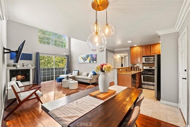 4211 Arch Dr Unit 201, Studio City, CA 91604 - dining space featuring a glass covered fireplace, recessed lighting, crown molding, and light wood-style floors