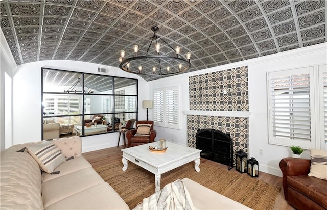 728 Euclid St, Santa Monica, CA 90402 - living room featuring a chandelier, wood finished floors, a tiled fireplace, plenty of natural light, and ornamental molding