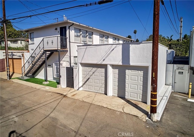 728 Euclid St, Santa Monica, CA 90402 - view of side of home with stucco siding, a garage, and stairway