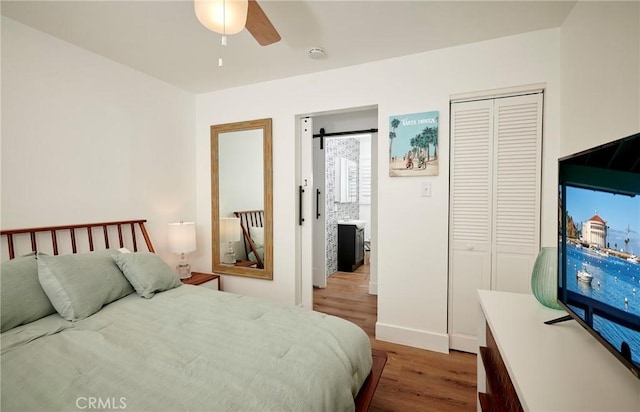 728 Euclid St, Santa Monica, CA 90402 - bedroom featuring wood finished floors, a closet, a barn door, and ceiling fan