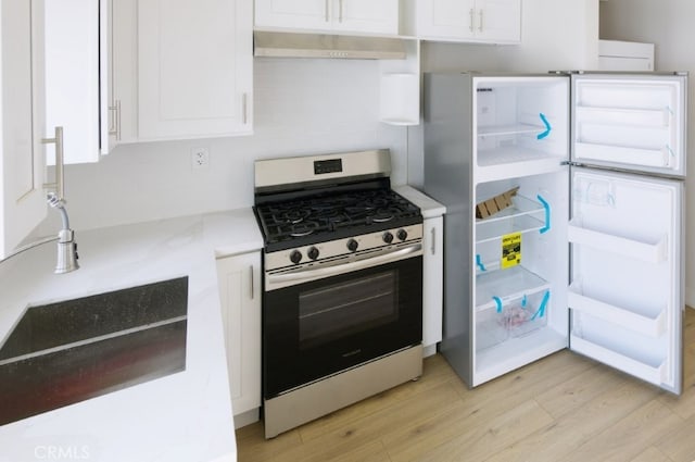 728 Euclid St, Santa Monica, CA 90402 - kitchen with gas range, freestanding refrigerator, ventilation hood, and white cabinets