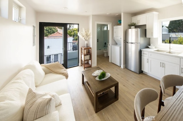 728 Euclid St, Santa Monica, CA 90402 - living area featuring stacked washer / drying machine and light wood-style floors