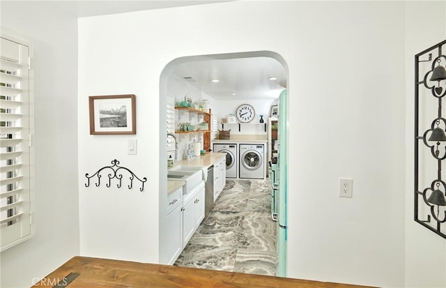 728 Euclid St, Santa Monica, CA 90402 - hallway featuring washer and dryer, arched walkways, and light marble finish floors