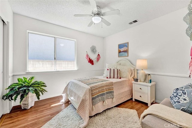 3401 Mountainside Cir, Corona, CA 92882 - bedroom featuring wood finished floors, a textured ceiling, and a ceiling fan
