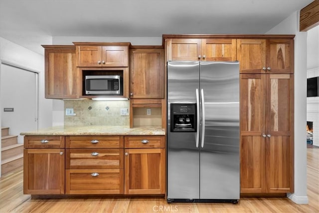11 Dapplegray Ln, Rolling Hills Estates, CA 90274 - kitchen with appliances with stainless steel finishes, brown cabinets, light wood-style flooring, decorative backsplash, and light stone countertops