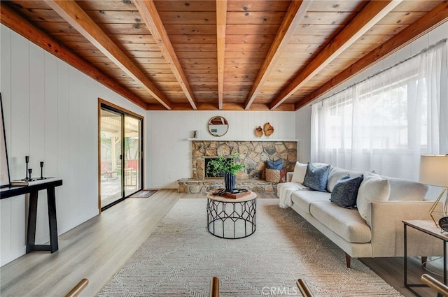 5856 E Scrivener St, Long Beach, CA 90808 - living room featuring light wood-style flooring, a wooden ceiling with exposed beams, and a stone fireplace