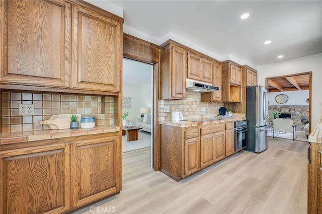 5856 E Scrivener St, Long Beach, CA 90808 - kitchen with freestanding refrigerator, under cabinet range hood, tile countertops, light wood-style flooring, and recessed lighting