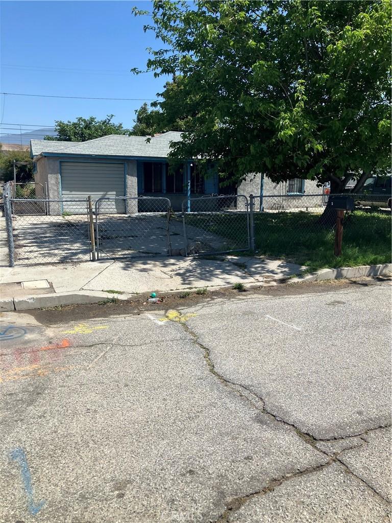 1946 W 19th St, San Bernardino, CA 92411 - view of front facade with a garage, a fenced front yard, and driveway