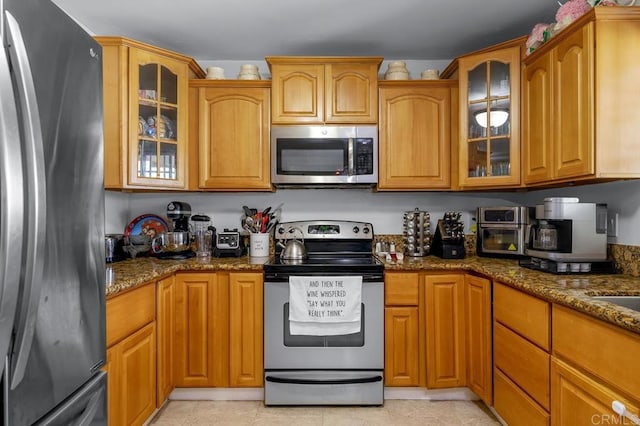 7215 San Pasqual St, Lemon Grove, CA 91945 - kitchen featuring stainless steel appliances, dark stone counters, glass insert cabinets, and brown cabinets