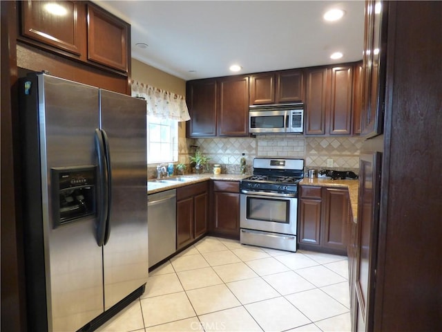 630 W Santa Cruz St, San Pedro, CA 90731 - kitchen featuring stainless steel appliances, backsplash, light tile patterned flooring, light stone counters, and recessed lighting