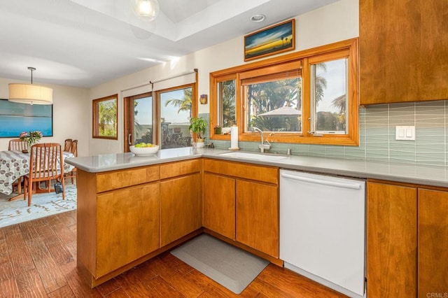 157 Beechtree Dr, Encinitas, CA 92024 - kitchen featuring dishwasher, a peninsula, dark wood finished floors, tasteful backsplash, and light countertops