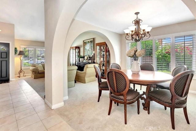 28021 Paseo Reposo, San Juan Capistrano, CA 92675 - dining space featuring light colored carpet, a chandelier, arched walkways, and light tile patterned flooring