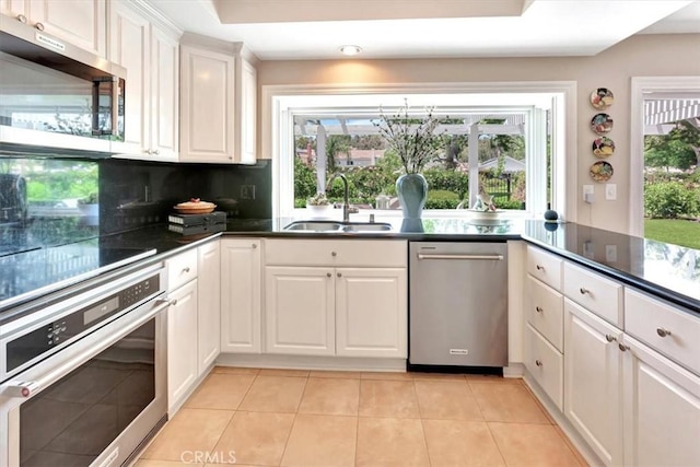 28021 Paseo Reposo, San Juan Capistrano, CA 92675 - kitchen featuring appliances with stainless steel finishes, white cabinets, light tile patterned floors, and dark countertops