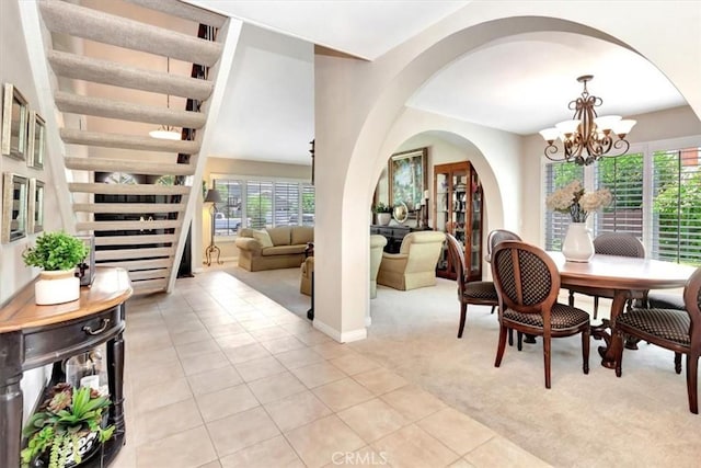 28021 Paseo Reposo, San Juan Capistrano, CA 92675 - dining space featuring a chandelier, light carpet, stairs, and arched walkways