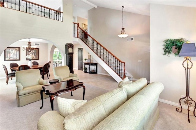 28021 Paseo Reposo, San Juan Capistrano, CA 92675 - living area featuring arched walkways, stairway, a chandelier, carpet flooring, and high vaulted ceiling