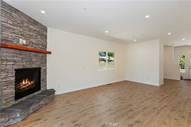 26182 Sky Ridge Dr, Twin Peaks, CA 92391 - unfurnished living room featuring wood finished floors, a stone fireplace, and recessed lighting