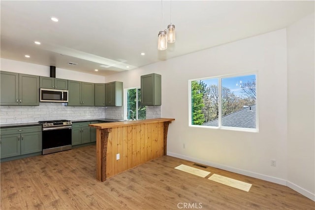 26182 Sky Ridge Dr, Twin Peaks, CA 92391 - kitchen featuring stainless steel appliances, green cabinets, tasteful backsplash, a peninsula, and recessed lighting