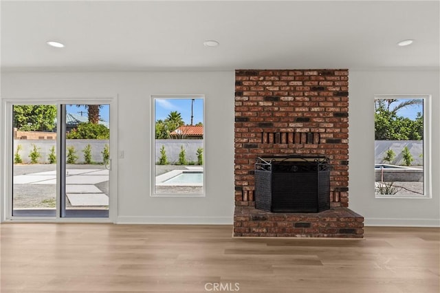 2852 E San Angelo Rd, Palm Springs, CA 92262 - unfurnished living room featuring wood finished floors, healthy amount of natural light, a fireplace, and recessed lighting