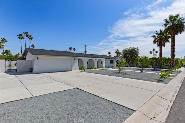 2852 E San Angelo Rd, Palm Springs, CA 92262 - ranch-style home with stucco siding, driveway, an attached garage, and a gate