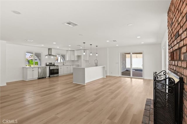 2852 E San Angelo Rd, Palm Springs, CA 92262 - living room featuring healthy amount of natural light, a brick fireplace, light wood finished floors, and recessed lighting