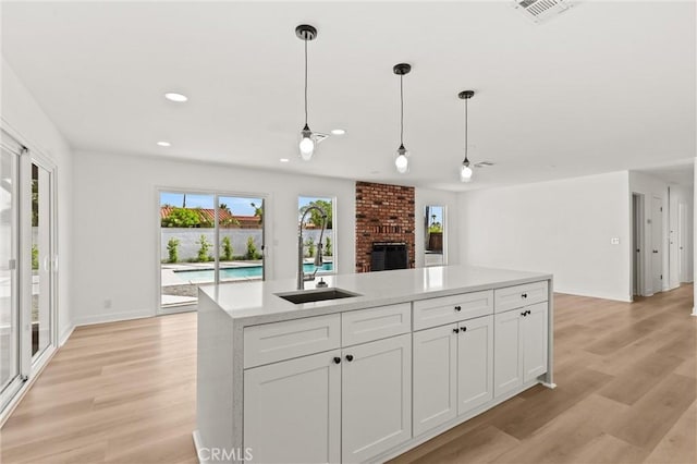 2852 E San Angelo Rd, Palm Springs, CA 92262 - kitchen featuring light wood-style flooring, open floor plan, light countertops, white cabinets, and recessed lighting