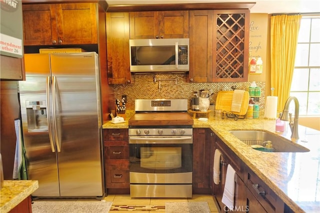 4140 Workman Mill Rd Unit 234, Whittier, CA 90601 - kitchen with appliances with stainless steel finishes, decorative backsplash, and light stone countertops