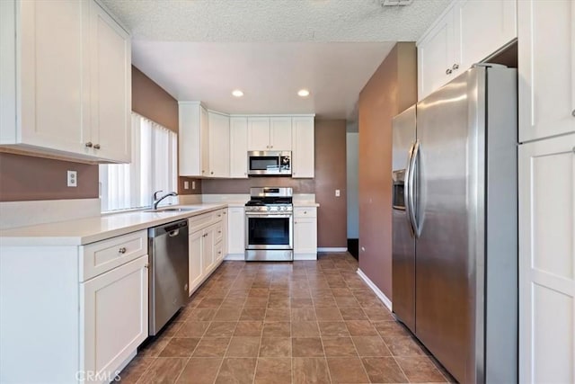 12976 Rhodes Pl, Chino, CA 91710 - kitchen featuring stainless steel appliances, white cabinetry, recessed lighting, light countertops, and a textured ceiling
