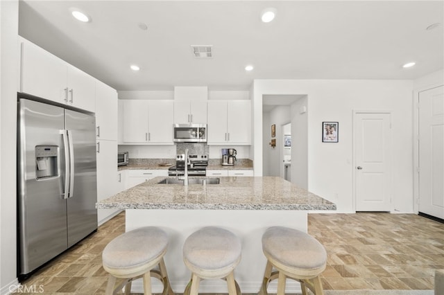 36351 Elizabeth Ln Unit 8105, Wildomar, CA 92595 - kitchen featuring stainless steel appliances, a breakfast bar area, white cabinets, a kitchen island with sink, and recessed lighting
