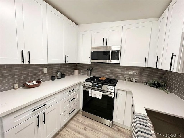 12361 El Rey Pl Unit 16, Garden Grove, CA 92840 - kitchen with appliances with stainless steel finishes, white cabinets, and tasteful backsplash