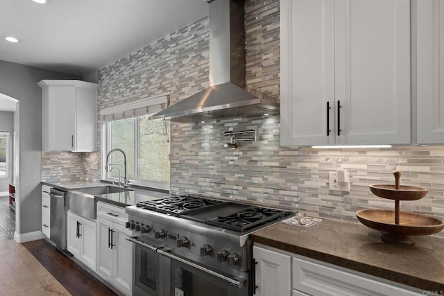 3676 Valley Rd, Bonita, CA 91902 - kitchen with wall chimney range hood, appliances with stainless steel finishes, backsplash, white cabinetry, and dark countertops