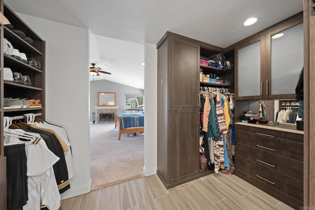 3676 Valley Rd, Bonita, CA 91902 - walk in closet featuring ceiling fan, light wood finished floors, vaulted ceiling, and a glass covered fireplace