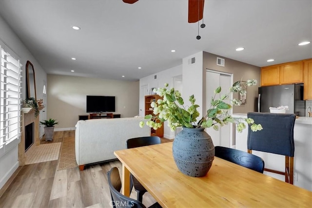 11 Exeter, Irvine, CA 92612 - dining area featuring recessed lighting, light wood-style flooring, a ceiling fan, and a glass covered fireplace