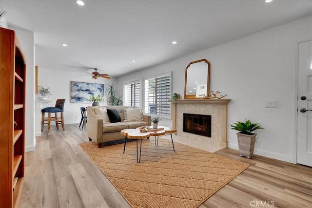 11 Exeter, Irvine, CA 92612 - living room with a ceiling fan, a tiled fireplace, light wood-type flooring, and recessed lighting