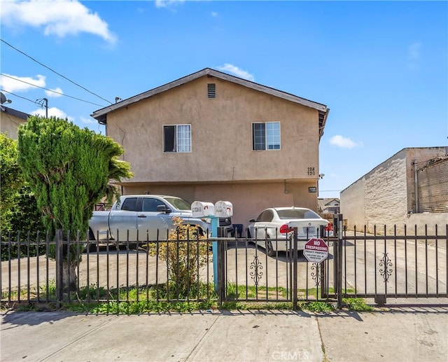 730 W 52nd Pl, Los Angeles, CA 90037 - view of front of property with a fenced front yard, stucco siding, and a garage