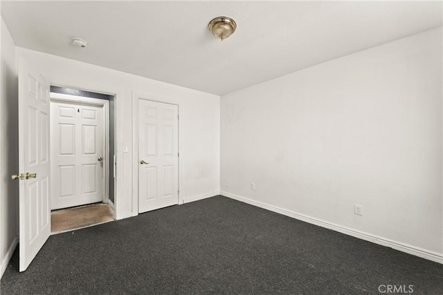 730 W 52nd Pl, Los Angeles, CA 90037 - unfurnished bedroom with dark carpet and baseboards