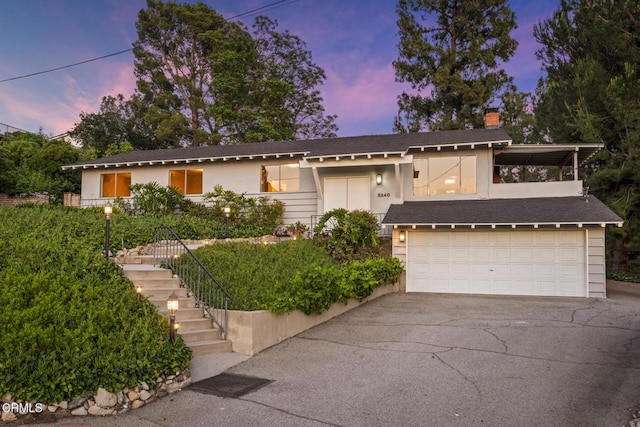 5240 Ramsdell Ave, La Crescenta, CA 91214 - view of front of home with asphalt driveway, a chimney, stairway, a garage, and a shingled roof