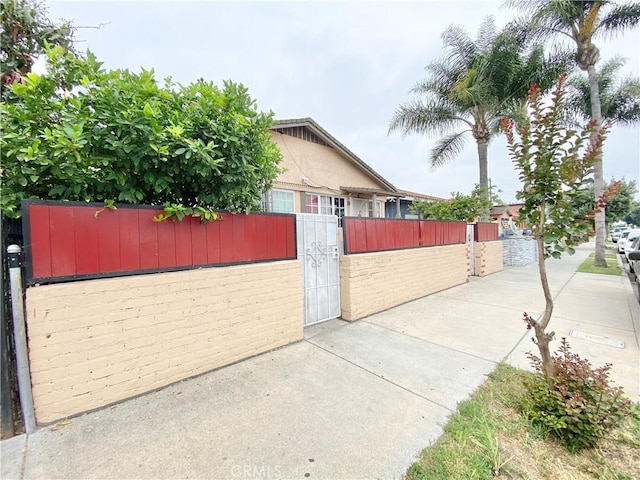 218 E 60th St, Los Angeles, CA 90003 - view of side of home with a gate and brick siding