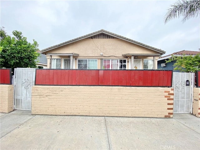 218 E 60th St, Los Angeles, CA 90003 - bungalow-style home featuring a gate and stucco siding