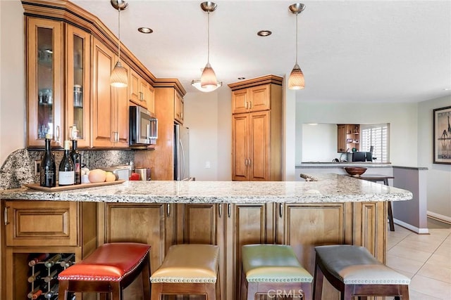 3811 E Livingston Dr Unit 1, Long Beach, CA 90803 - kitchen featuring stainless steel microwave, refrigerator, a peninsula, light stone countertops, and backsplash