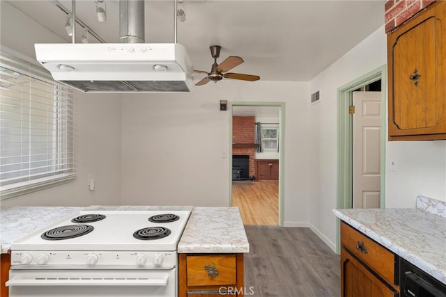 1220 Bidwell Ave, Chico, CA 95926 - kitchen with white range with electric stovetop, ceiling fan, under cabinet range hood, light wood-style floors, and brown cabinets