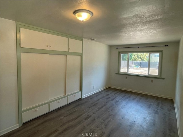 1220 Bidwell Ave, Chico, CA 95926 - unfurnished bedroom with dark wood-type flooring, a textured ceiling, and a closet