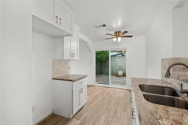 9912 Marshall St, El Monte, CA 91731 - kitchen with light stone countertops, light wood-style floors, and white cabinets