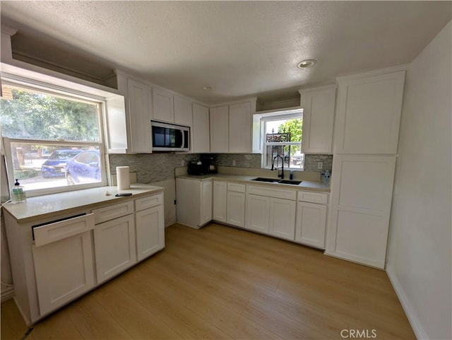 10051 Orchard St, Bloomington, CA 92316 - kitchen featuring stainless steel microwave, backsplash, light wood-style floors, recessed lighting, and a textured ceiling