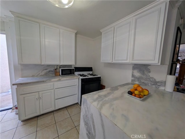 10051 Orchard St, Bloomington, CA 92316 - kitchen featuring gas range, black microwave, white cabinets, light countertops, and light tile patterned floors