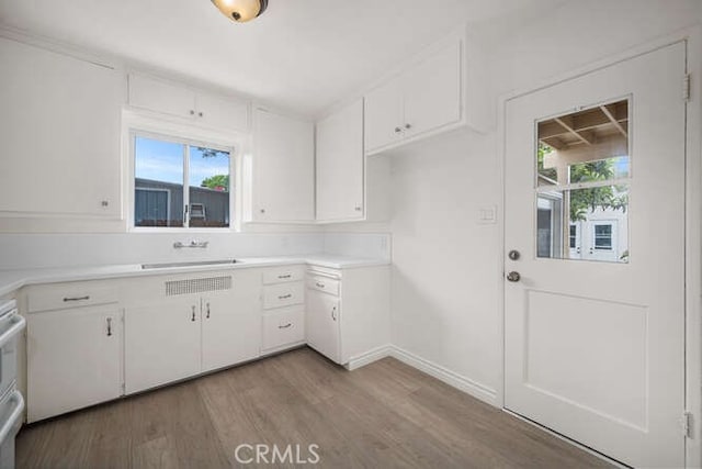 338 Prospect Ave, Long Beach, CA 90814 - kitchen featuring white cabinetry, light wood-type flooring, light countertops, and stove