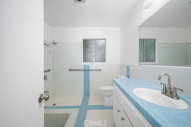 338 Prospect Ave, Long Beach, CA 90814 - full bathroom featuring tile walls, vanity, a shower, and a wainscoted wall